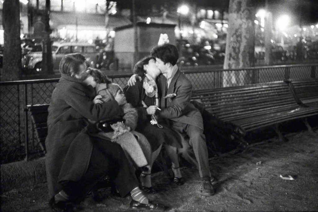 Fotografia di Sabine Weiss rappresentante due coppie che si baciano su una panchina.